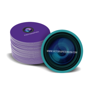 Graphics Design Media prints round business cards, pictured here in purple and teal for a photography business with a camera lens design.
