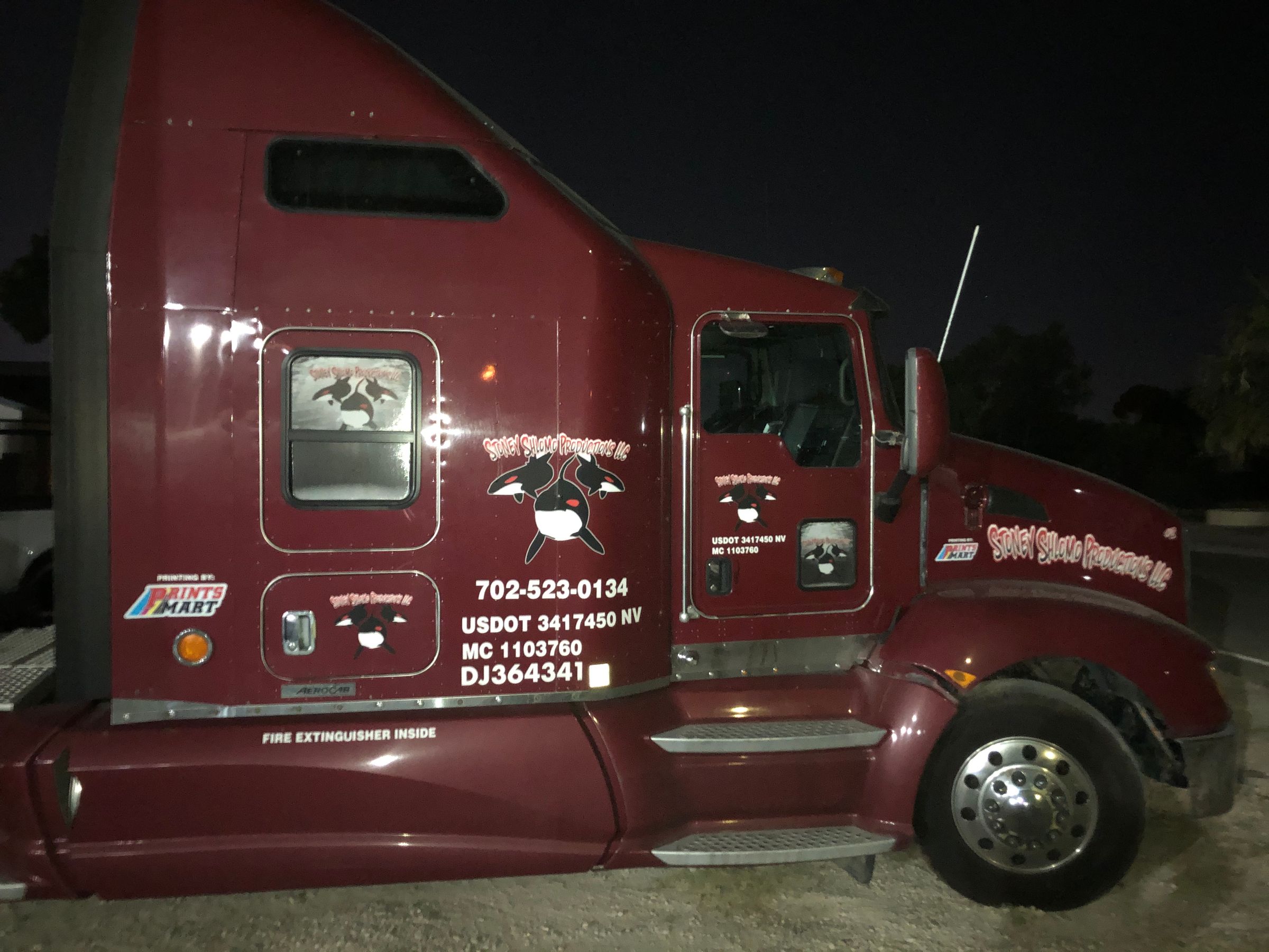 Maroon semi truck with custom logo and USDOT lettering