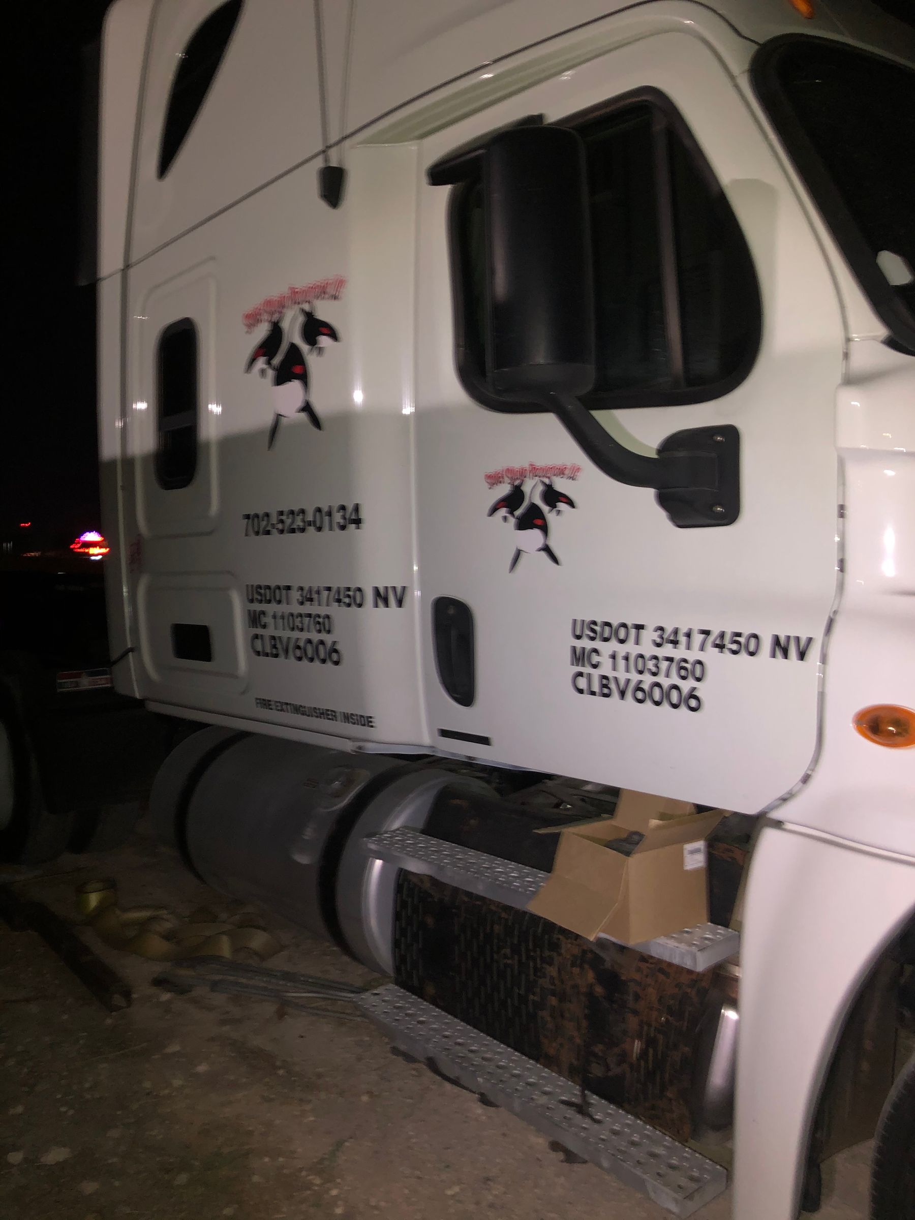 Side view of a semi truck with vinyl door lettering