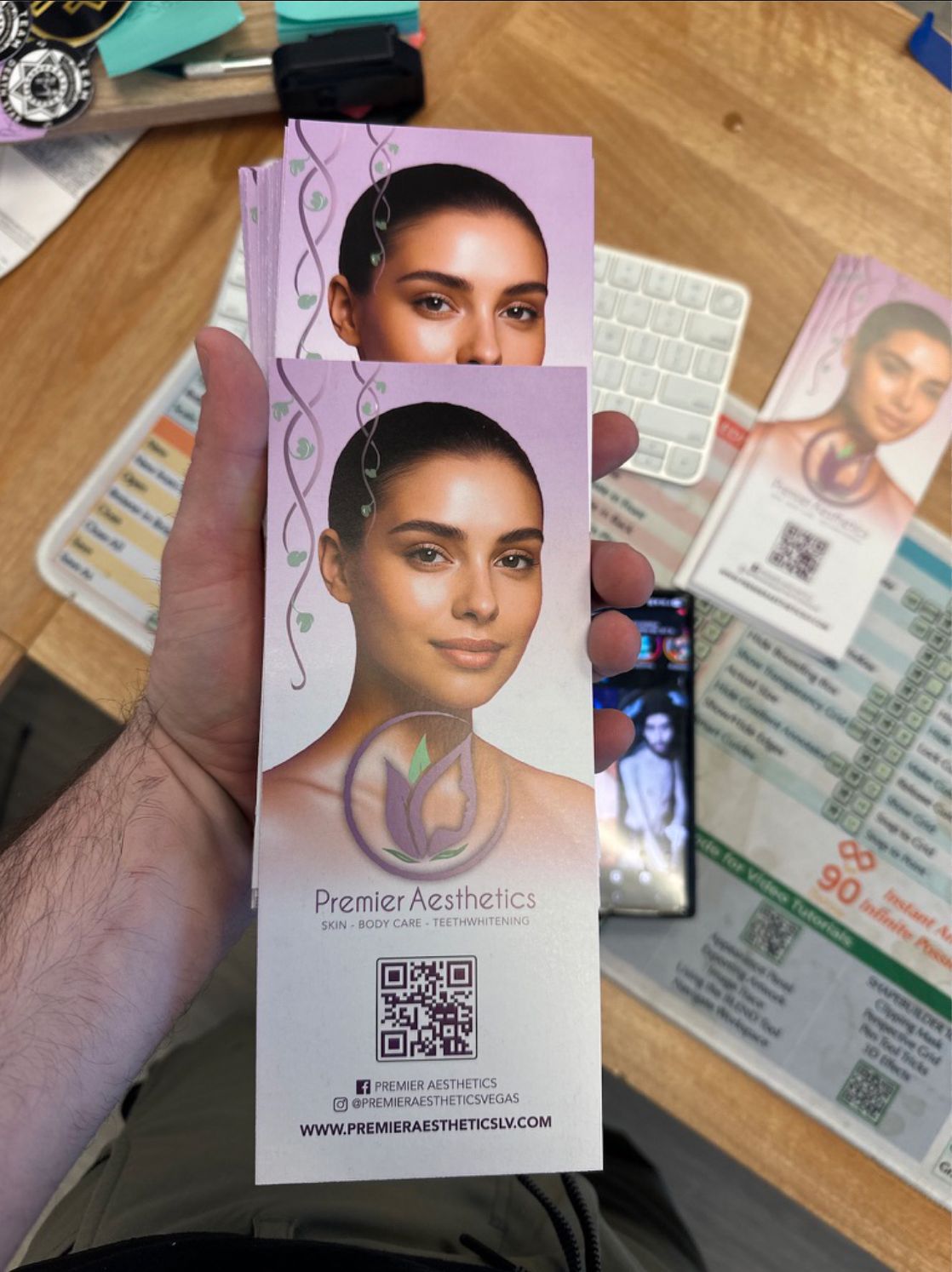 Hand holding printed trifold brochures for Premier Aesthetics