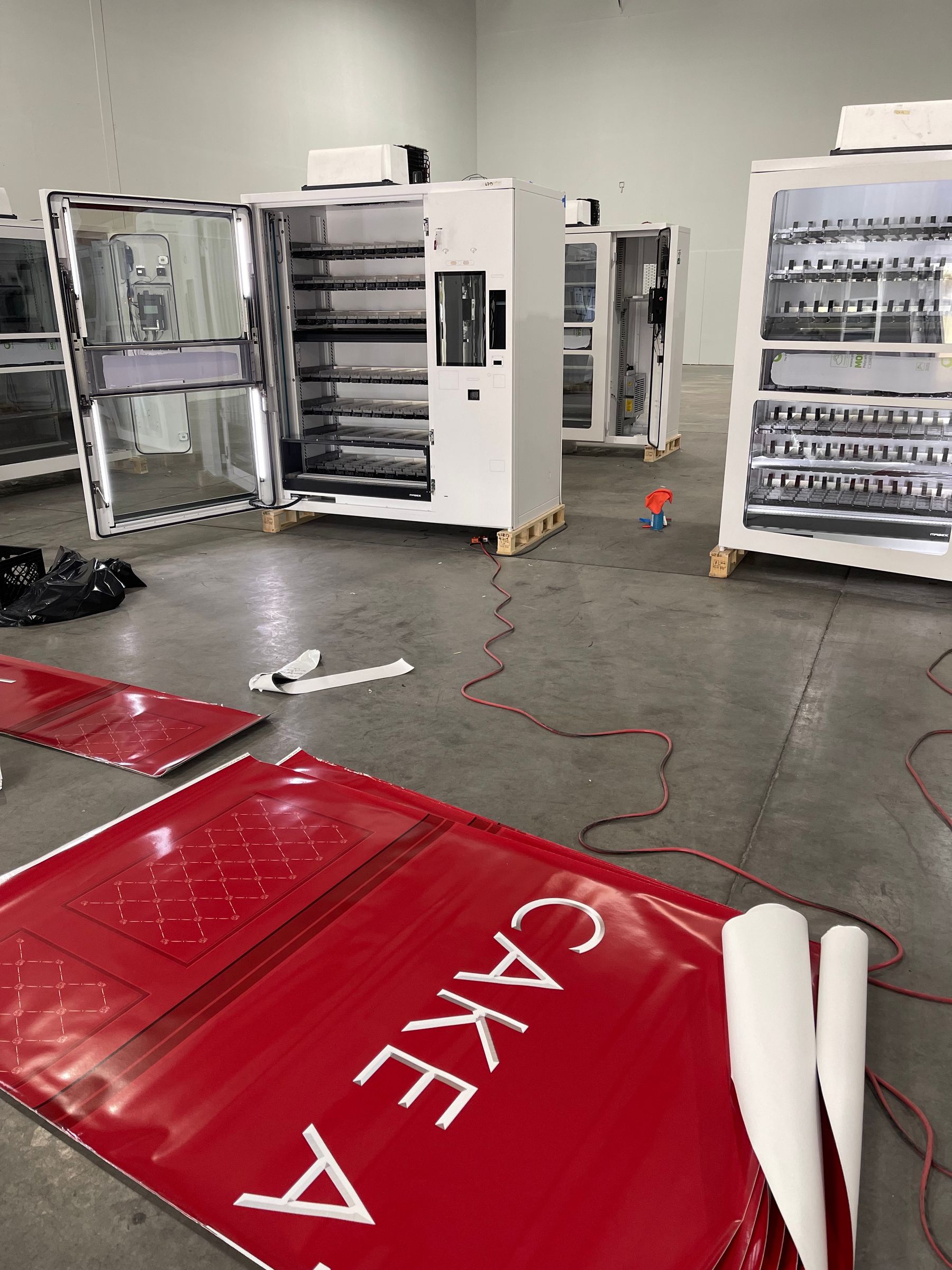 Vending machines being wrapped with printed vinyl in the shop